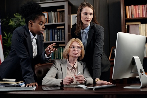 Picture of three women looking at a computer display and having a discussion